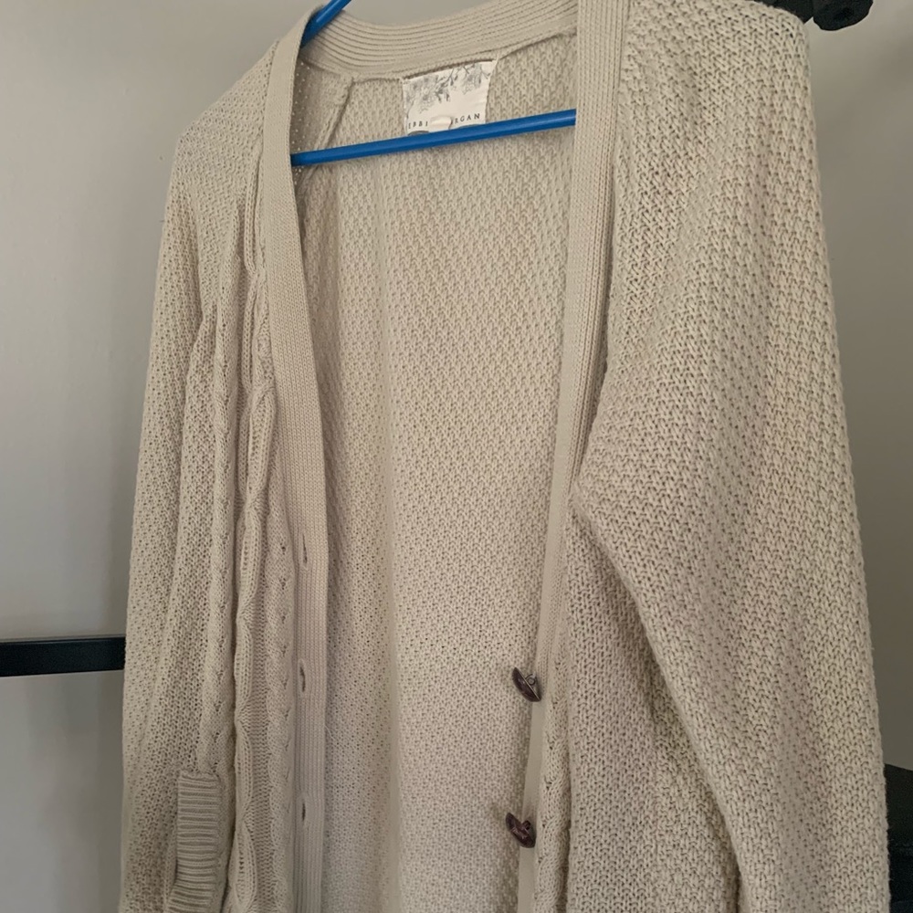 Beige cardigan with brown buttons. It is from Debbie Morgan.